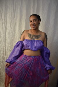 Adrianna in a jessa hand made purple off the shoulder top wiutha reversible silk skirt
